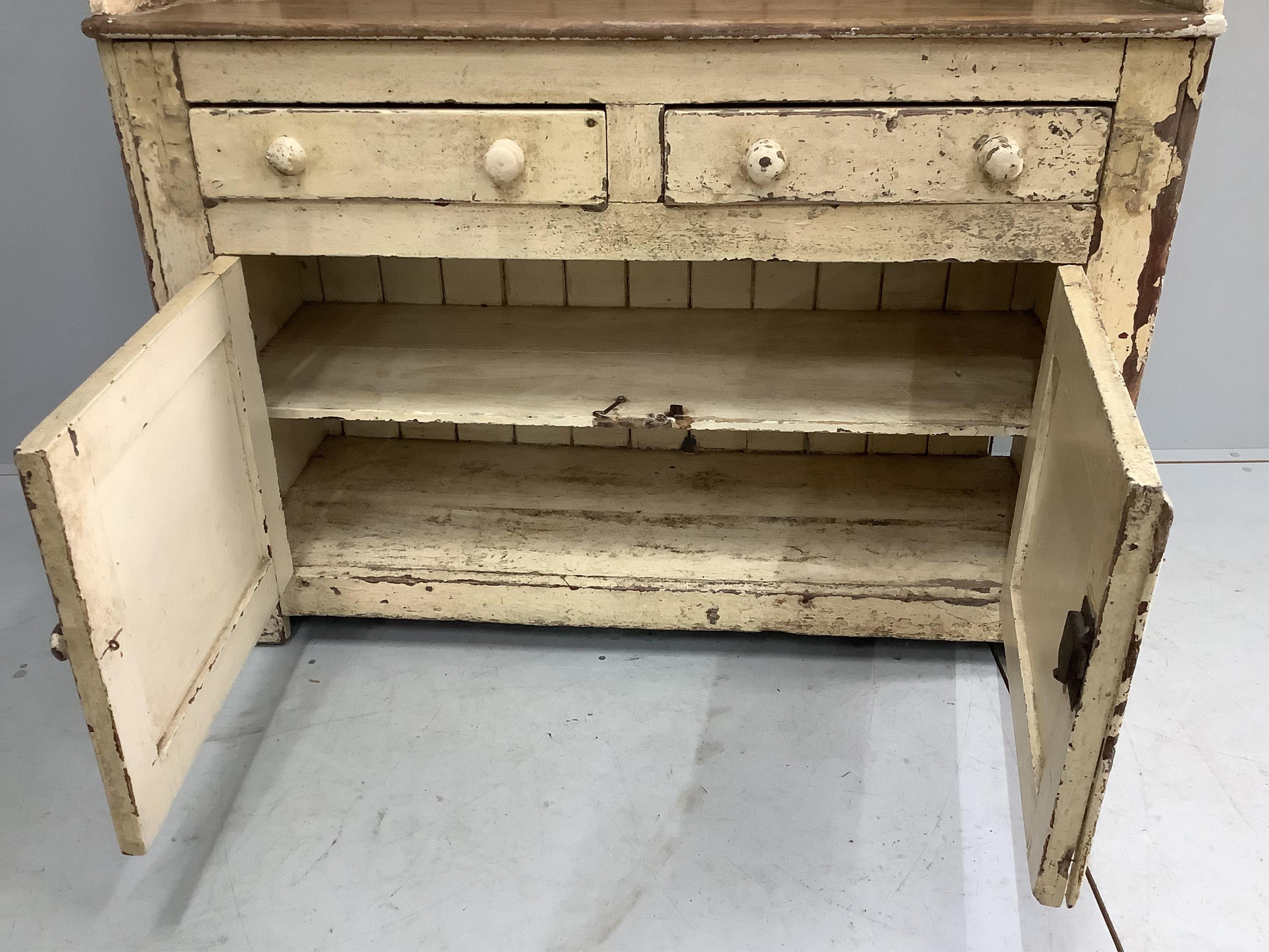 An early 19th century Irish painted pine dresser with boarded rack, width 126cm, depth 49cm, height 210cm. Condition - fair